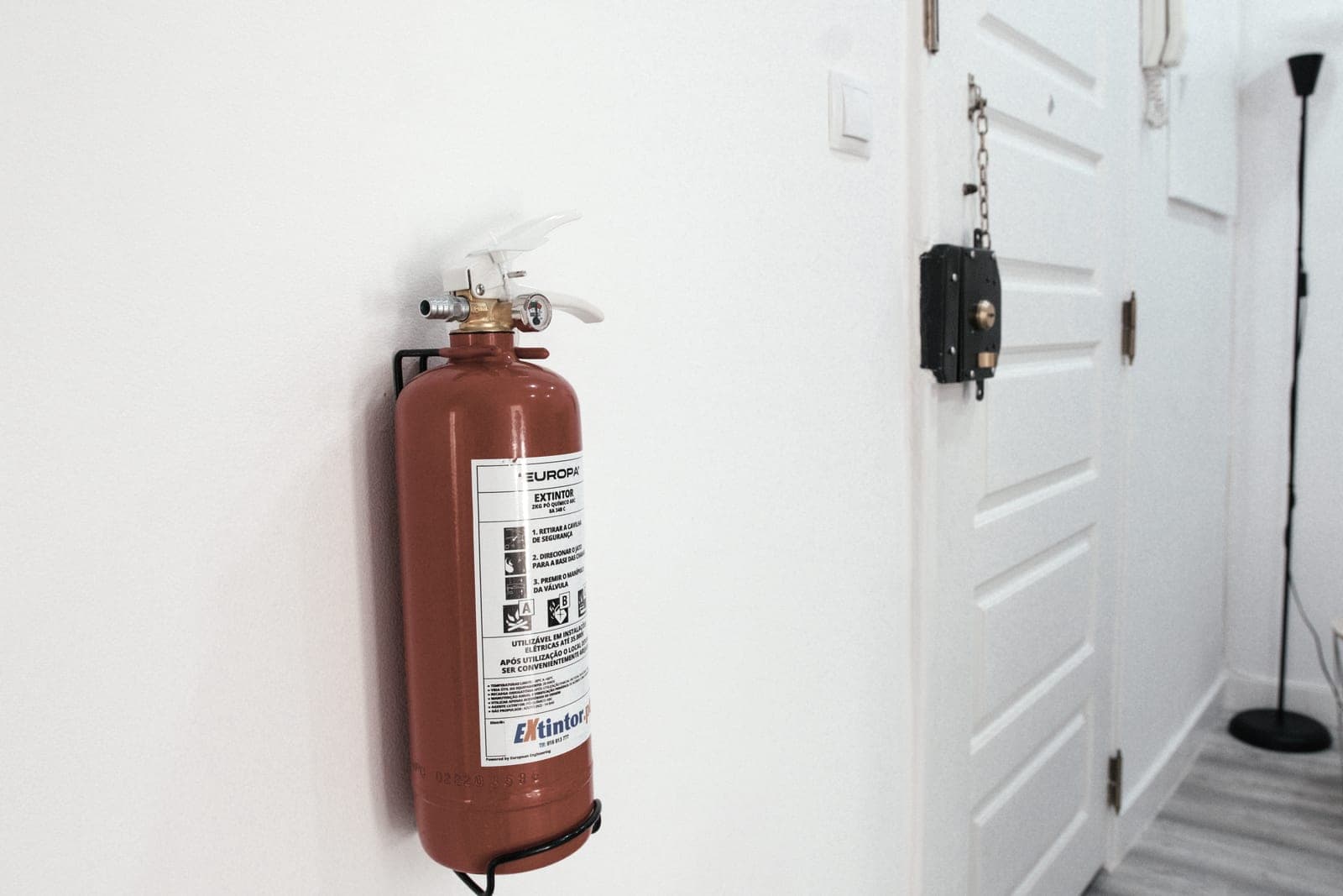 A wall-mounted fire extinguisher in a clean, brightly lit interior