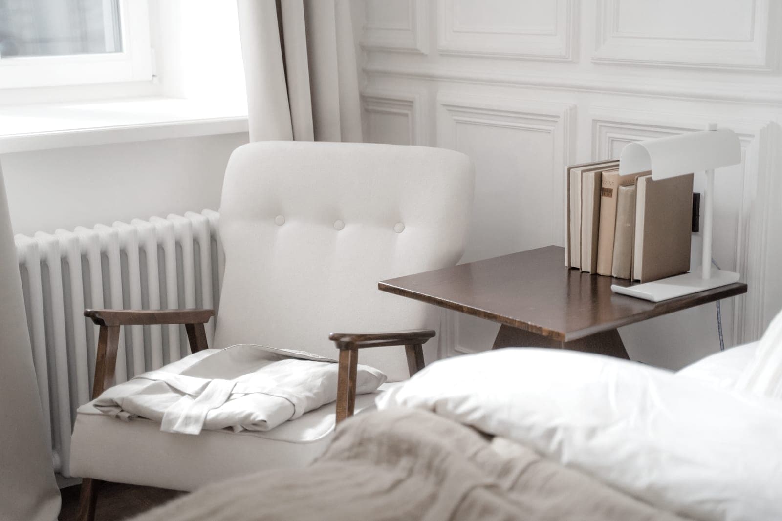 A small, bright bedroom corner with a chair beside a window