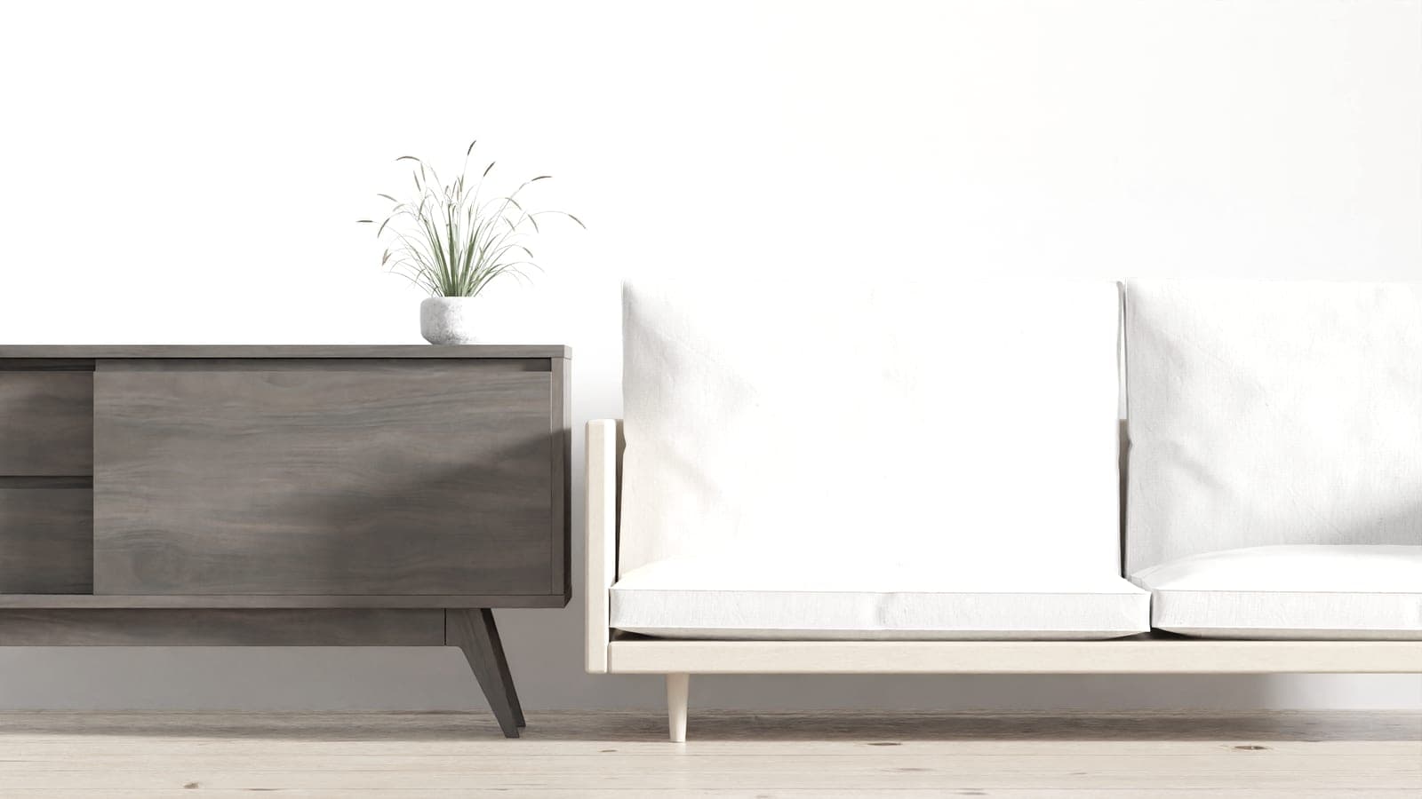 A pale, softly lit living room with a low white sofa against a plain wall